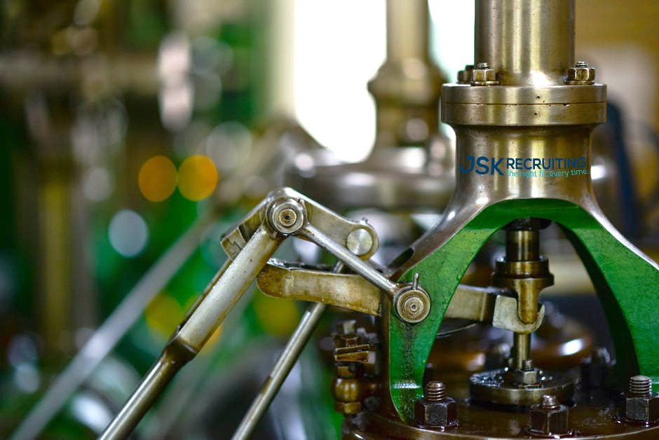 A closeup of an industrial manufacturing machine emblazoned with the JSK Recruiting logo.