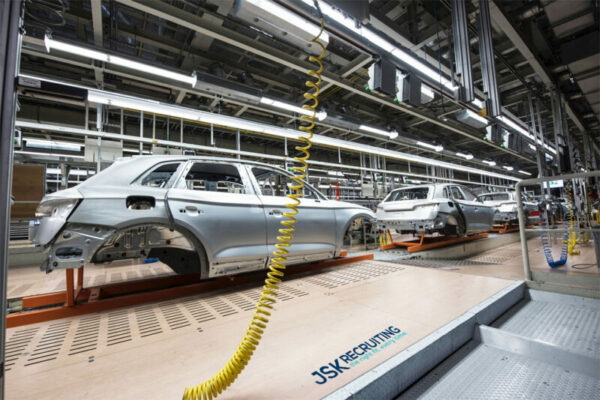 A car assembly line with cars on the conveyer belt.