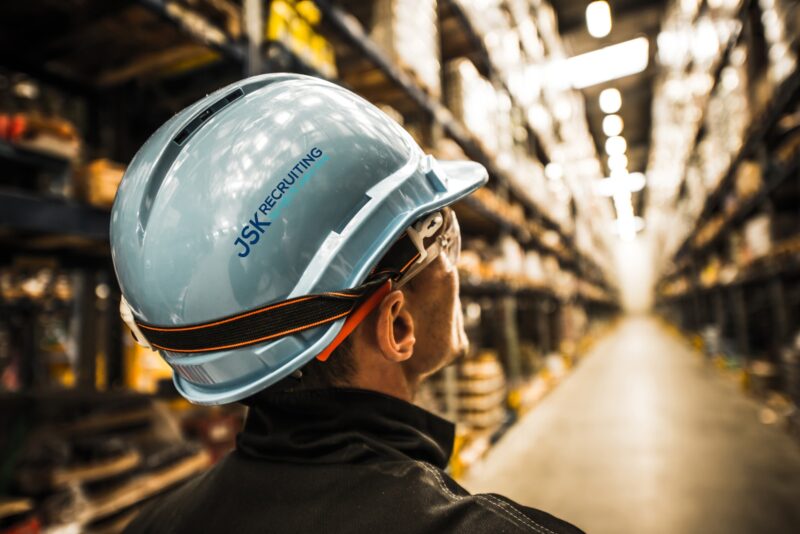 Modern Warehouse Worker in Safety Helmet and Goggles