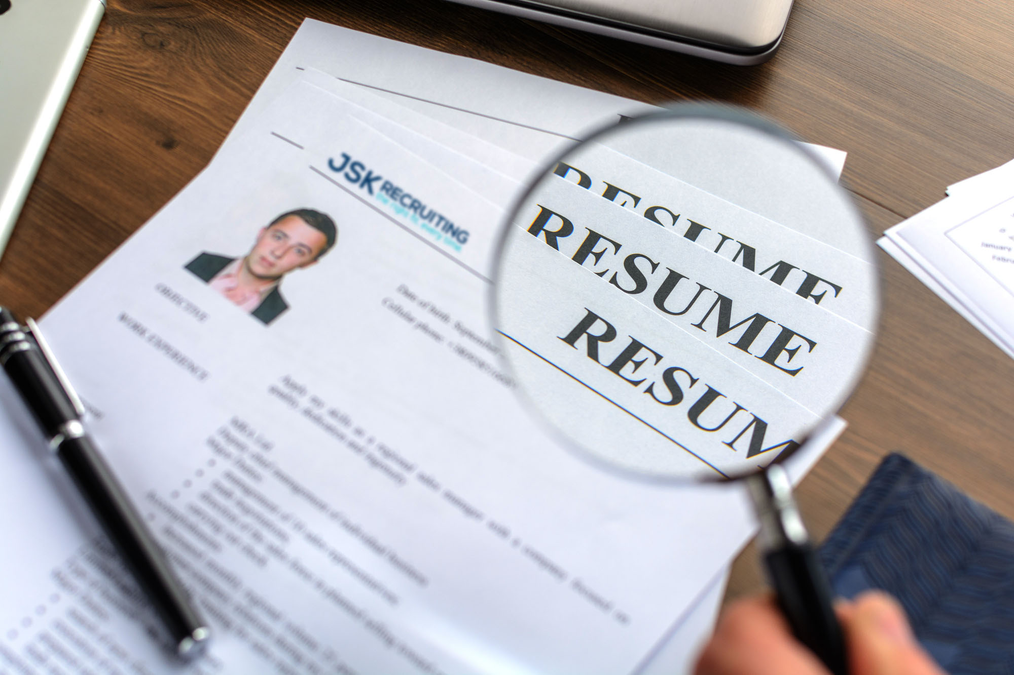 A person is looking at the resume with a magnifying glass.